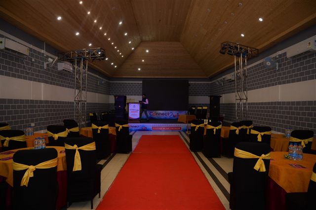 Red carpet aisle leading to a stage with gold chair sashes